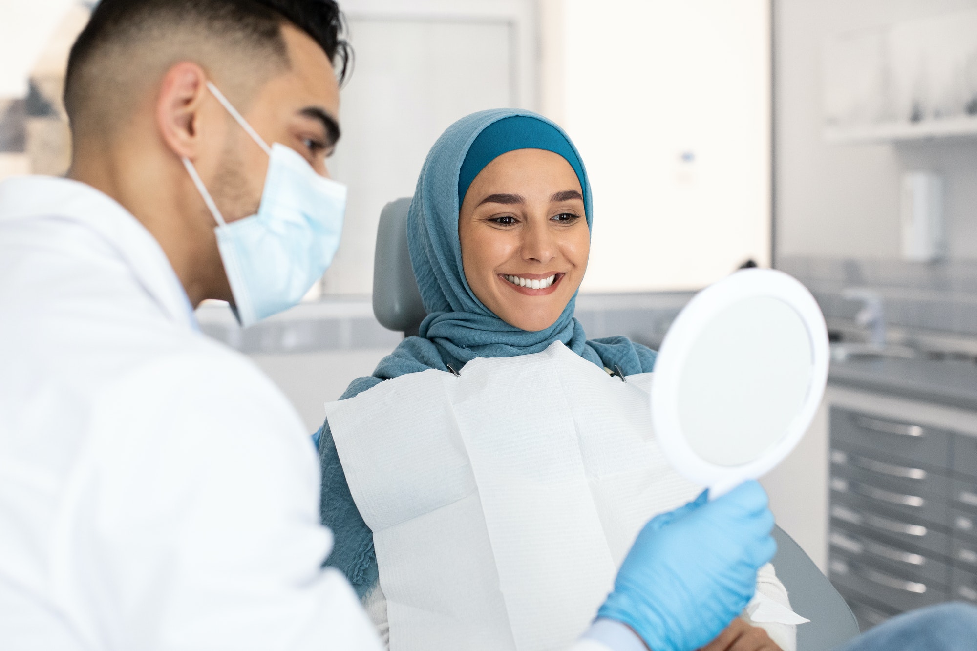 Muslim Lady In Hijab Looking At Her New Smile After Teeth Treatment
