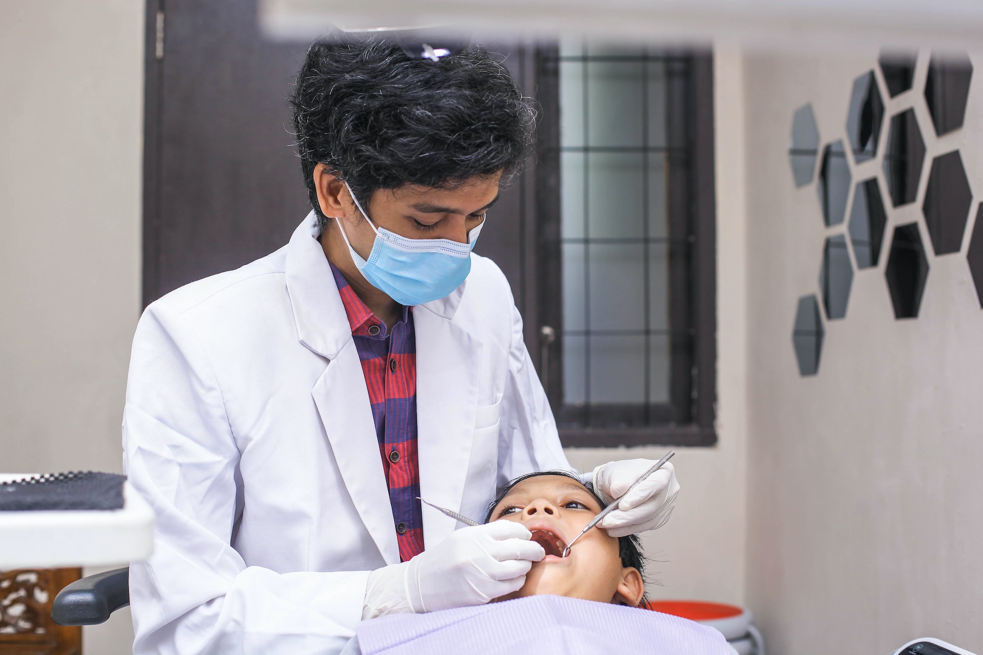 Dentist examining boy patient teeth