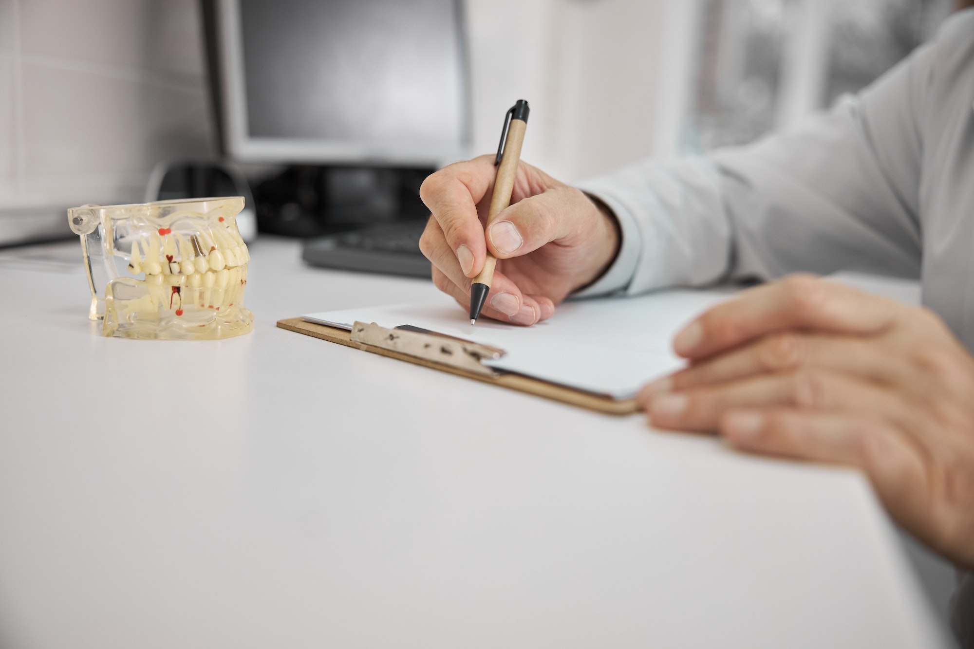 Dentist writing a prescription for dental implant