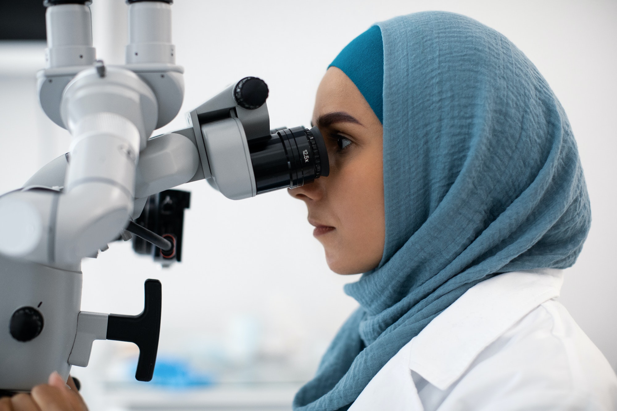 Modern Dentistry. Muslim Female Doctor In Hijab Using Dental Surgical Microscope, Closeup