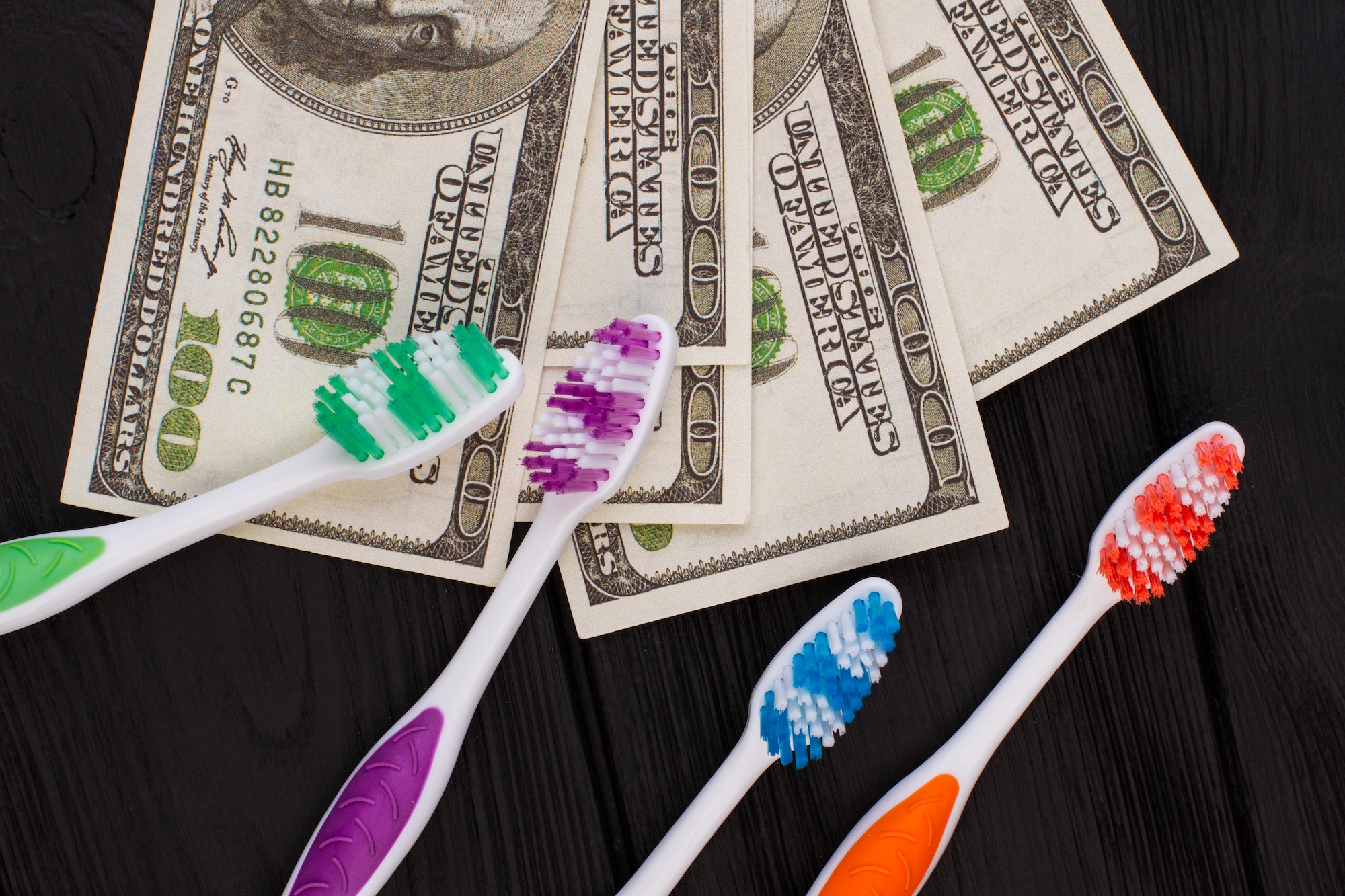 Toothbrush and money on black background